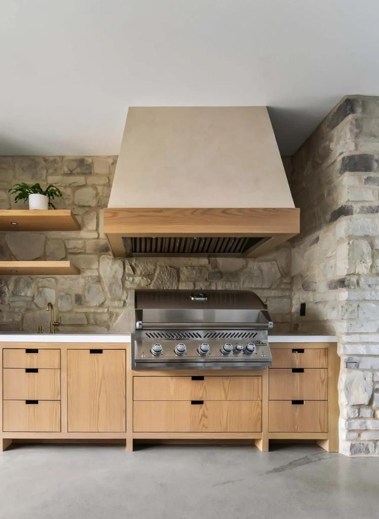 Cuisine extérieure en bois avec BBQ encastré et mur de pierre